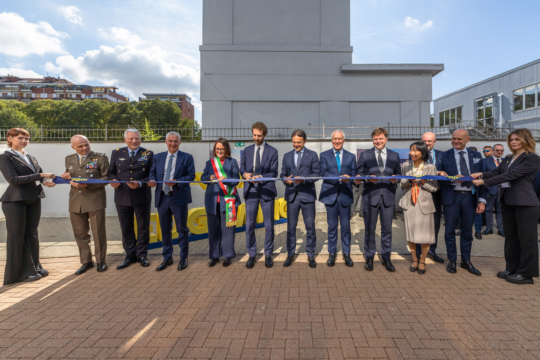 People standing with a ribbon in front of a building opening
